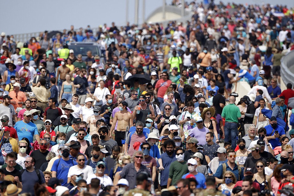 Spectators walk from their vantage point on a bridge in Titusville, Fla. after watching SpaceX Falcon 9 lift off with NASA astronauts Doug Hurley and Bob Behnken in the Dragon crew capsule, Saturday, May 30, 2020 from the Kennedy Space Center at Cape Canaveral, Fla. The two astronauts are on the SpaceX test flight to the International Space Station. For the first time in nearly a decade, astronauts blasted towards orbit aboard an American rocket from American soil, a first for a private company. (AP Photo/Charlie Riedel)