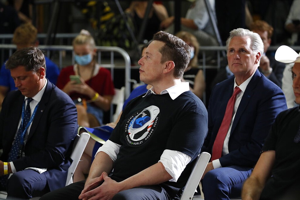 Tesla and SpaceX Chief Executive Officer Elon Musk listens during an event at the Vehicle Assembly Building on Saturday, May 23, 2020, after a SpaceX flight at NASA's Kennedy Space Center in Cape Canaveral, Fla. A rocket ship designed and built by SpaceX lifted off on Saturday with two Americans on a history-making flight to the International Space Station. (AP Photo/Alex Brandon)