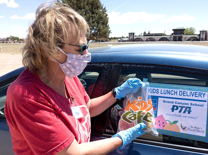 Grand Canyon School PTA President Cherie Benefield displays a bagged meal handed out for the summer lunch program May 27. (Abigail Kessler/WGCN)