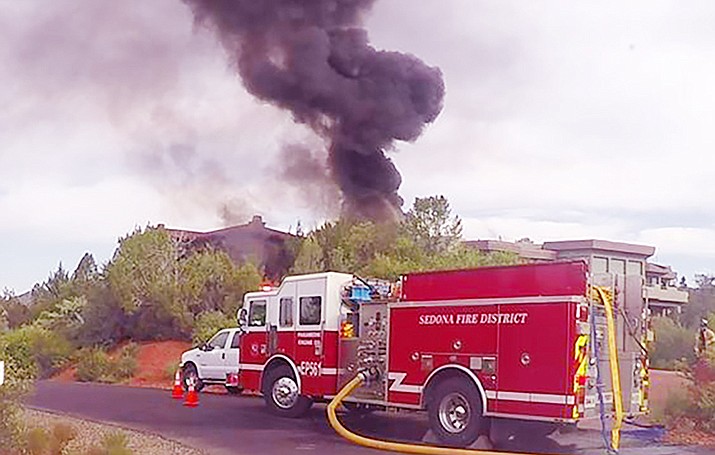 Sedona firefighters needed to act fast to contain and put out a structure fire on Acacia Drive, north of  Chapel Road and east of State Route 179, Friday morning. A tar pot malfunctioned and caught on fire, catching two vehicles and a portion of a house on fire. Courtesy of Sedona Fire District