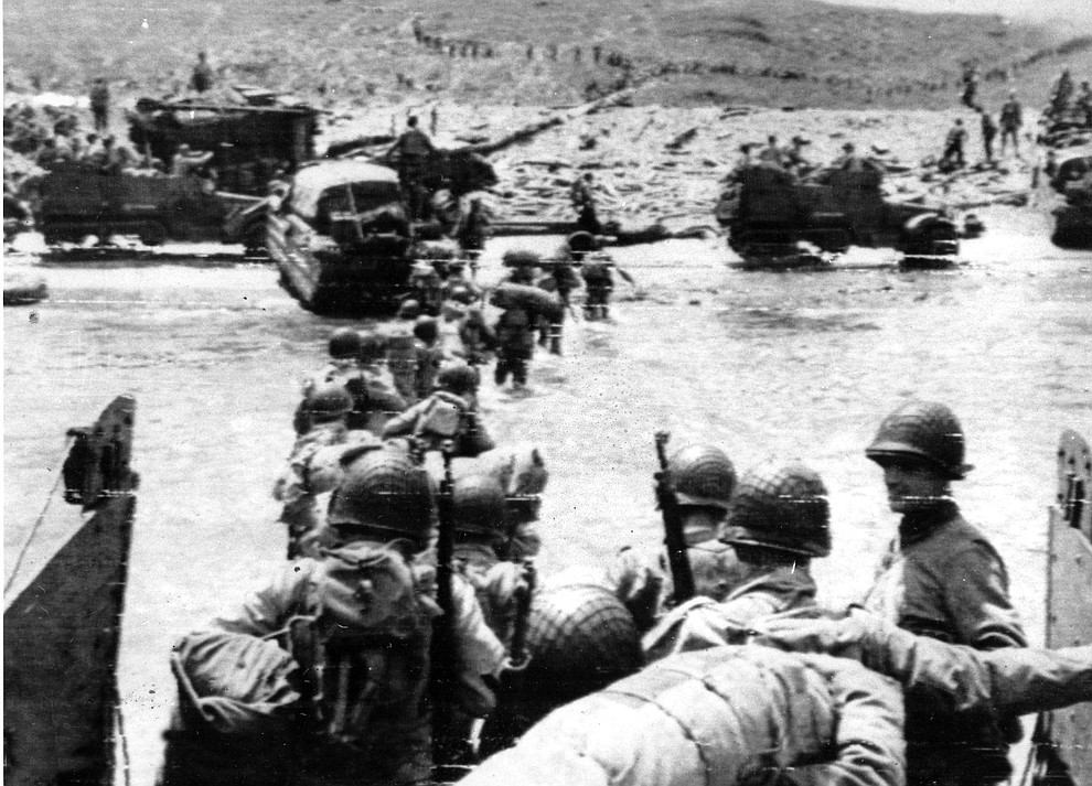 Ducks (amphibious trucks) and a half-track follow foot troops ashore during the invasion of Normandy on a 100-mile front along the French coast by allied forces on June 6, 1944. This was a turning point for the Allies in World War II, known as D-Day. (AP Photo)..