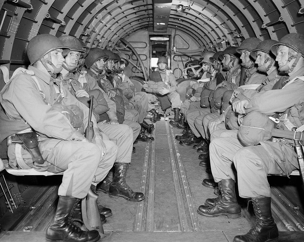 American paratroopers, heavily armed, sit inside a military plane as they soar over the English Channel en route to the Normandy French coast for the Allied D-Day invasion of the German stronghold during World War II, June 6, 1944. (AP Photo)