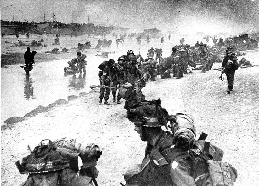 In this photo provided by the British Navy, wounded British troops from the South Lancashire and Middlesex regiments are being helped ashore at Sword Beach, June 6, 1944, during the D-Day invasion of German occupied France during World War II. (AP Photo/British Navy)..