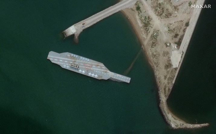 In this Sunday, June 7, 2020 satellite photo provided by Maxar Technologies, a fake aircraft carrier is seen off the coast of Bandar Abbas, Iran. As tensions remain high between Iran and the U.S., the Islamic Republic appears to have constructed a new mockup of an aircraft carrier off its southern coast for potential live-fire drills. The faux foe, seen in satellite photographs obtained by The Associated Press, resembles the Nimitz-class carriers that the U.S. Navy routinely sails into the Persian Gulf from the Strait of Hormuz, its narrow mouth that sees 20% of all the world's oil pass through it. (Satellite image by Maxar Technologies)