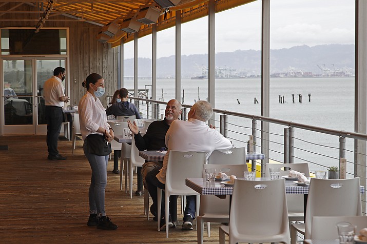 Customers of Mission Rock restaurant interact with their waitress on Friday, June 12, 2020, in San Francisco. Today was the first day outdoor dining is allowed in San Francisco restaurants since the COVID-19 pandemic began. (Ben Margot/AP)