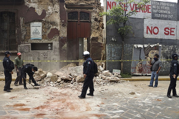 A policeman removes rubble from a building damaged by an earthquake in Oaxaca, Mexico, Tuesday, June 23, 2020. The earthquake was centered near the resort of Huatulco, in the southern state of Oaxaca. (Luis Alberto Cruz Hernandez/AP)