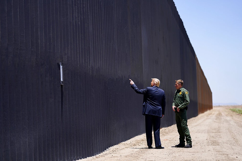 President Donald Trump speaks with Rodney Scott, the U.S. Border Patrol Chief, as he tours a section of the border wall, Tuesday, June 23, 2020, in San Luis, Ariz. (AP Photo/Evan Vucci)