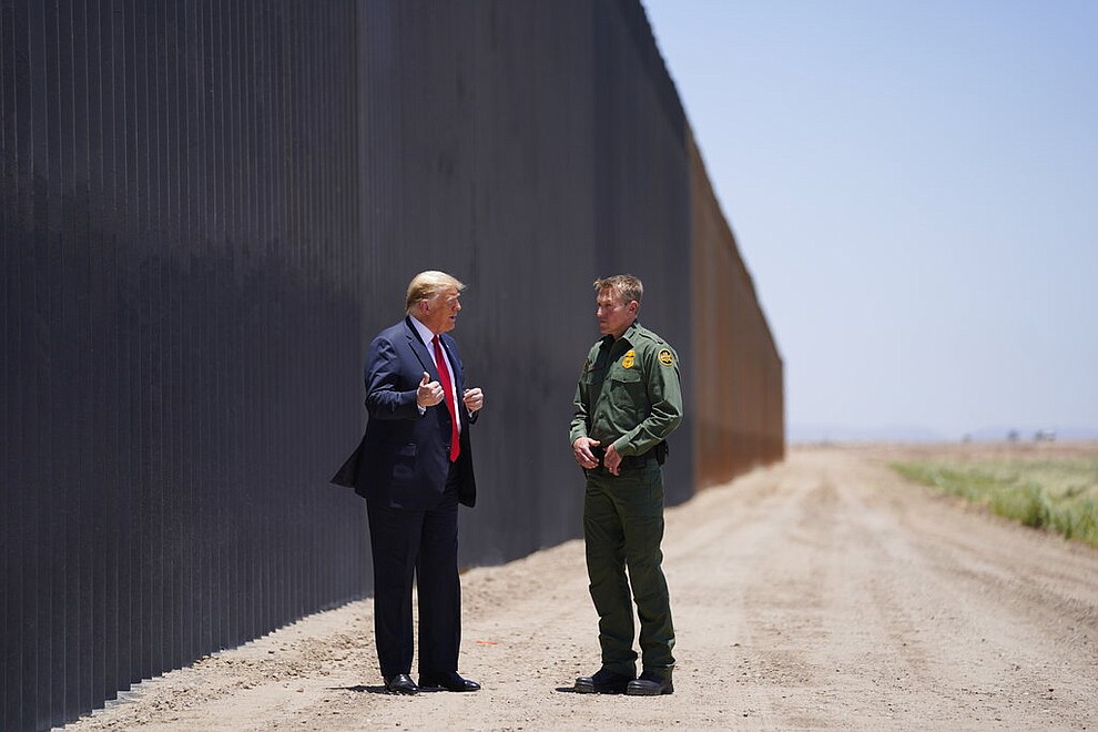 President Donald Trump speaks with Rodney Scott, the U.S. Border Patrol Chief, as he tours a section of the border wall, Tuesday, June 23, 2020, in San Luis, Ariz. (AP Photo/Evan Vucci)