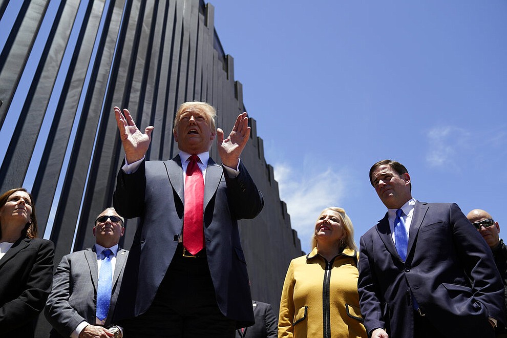 President Donald Trump speaks as he tours a section of the border wall, Tuesday, June 23, 2020, in San Luis, Ariz. Arizona Gov. Doug Ducey, second from right, and Rep. Debbie Lesko, R-Ariz., third from right. (AP Photo/Evan Vucci)