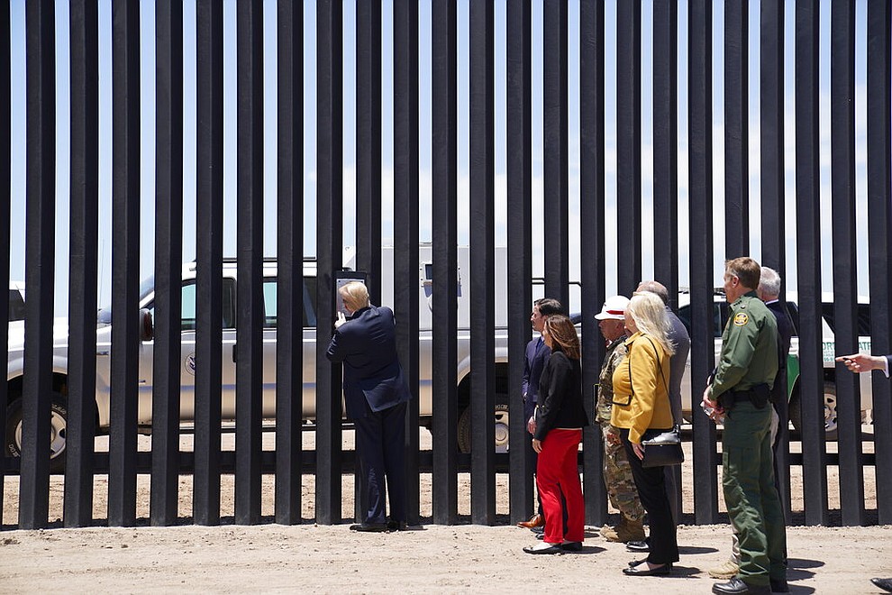 President Donald Trump signs a plaque as he tours a section of the border wall, Tuesday, June 23, 2020, in San Luis, Ariz. (AP Photo/Evan Vucci)