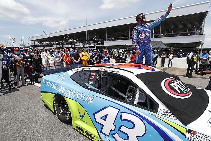 In this June 22, 2020, file photo, Bubba Wallace takes a selfie of himself and of other drivers who had pushed his car to the front in the pits at Talladega Superspeedway before the NASCAR Cup Series auto race in Talladega Ala., Monday June 22, 2020. The noose found hanging in Wallace's garage stall at Talladega had been there since at least last October, federal authorities said Tuesday, June 23, in announcing there will be no charges filed in an incident that rocked NASCAR and its only fulltime Black driver. (John Bazemore, AP File)