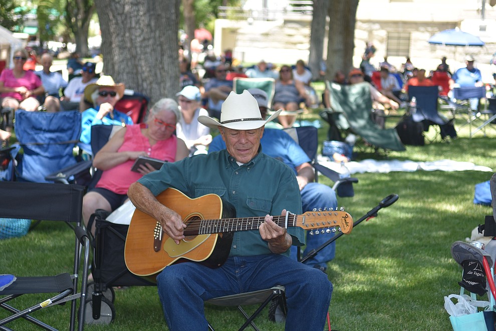 Mike Weatherford, 72, plays his guitars while watching Quick Sand Soup perfom at the Prescott Bluegrass Festival at the Yavapai County Courthouse on Saturday afternoon, June 27, 2020. (Jesse Bertel/Courier)