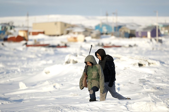 George Chakuchin, left, and Mick Chakuchin walk on ice over the Bering Sea in Toksook Bay, Alaska, a mostly Yuip’ik village. A federal judge has ruled that Alaska Native corporations are eligible for a share of coronavirus relief funding set aside for tribes. Congress included $8 million for tribes in a relief package approved earlier this year. (AP Photo/Gregory Bull, File)