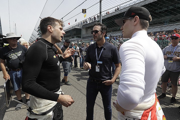 In this May 16, 2019, file photo, NASCAR driver Jimmie Johnson, center, talks with Will Power, left, of Australia, and Josef Newgarden during practice for the Indianapolis 500 IndyCar auto race at Indianapolis Motor Speedway in Indianapolis. The seven-time champion Johnson has tested positive for the coronavirus and will miss this weekend's race at Indianapolis Motor Speedway(Darron Cummings/AP)