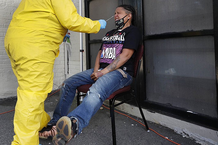 Naliber Tavares winces as she receives a COVID-19 test at the Whittier Street Health Center's mobile test site, Wednesday, July 15, 2020, in Boston's Dorchester section. The health center has administered free COVID-19 tests to over 5,000 people. The tests, administered since April 13, have been a popular service in Boston's low-income communities that have experienced high rates of infection. (Elise Amendola/AP)