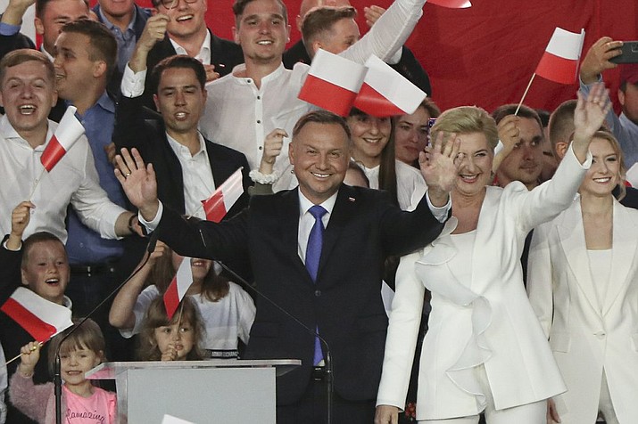 El presidente Andrzej Duda, acompañado por su esposa Agata Kornhauser-Duda, saluda a sus simpatizantes el domingo 12 de julio de 2020, en Pultusk, Polonia. (AP Foto/Czarek Sokolowski)