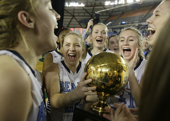 In this March 5, 2016 file photo, Central Valley players celebrate with the trophy after they beat Snohomish to win the Washington state girls 4A high school basketball championship in Tacoma, Wash. The overwhelming uncertainty of whether high school sports can go forward in the fall of 2020 amidst the continued COVID-19 pandemic is a constant refrain among administrators and decision makers as the clock ticks closer to the start of the 2020-21 school year with little clarity in place for an obvious and safe path moving forward for athletics. (Ted S. Warren/AP, file)