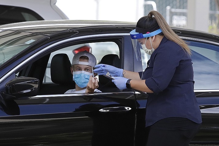 A healthcare worker takes information from a person at a Covid-19 testing center on Tuesday, July 21, 2020, in Pleasanton, Calif. (Ben Margot/AP)