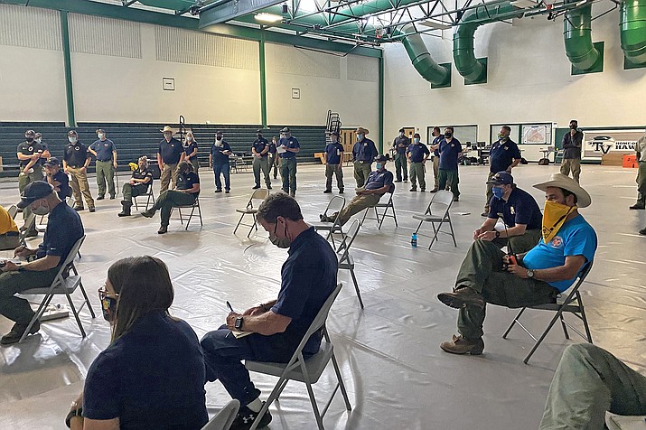 Wildland firefighters attend a socially distanced briefing at the Smokejumper Depot in Missoula, Mont. in July before the wildfire season begins. (photo/U.S. Forest Service via AP)