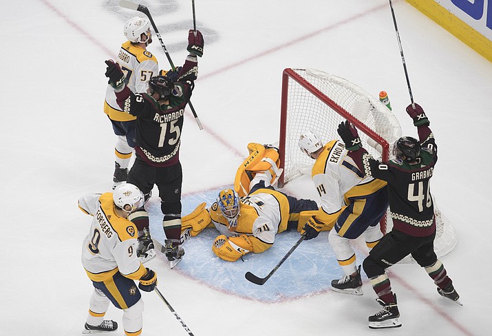 Nashville Predators goalie Juuse Saros (74) looks up from the ice as Arizona Coyotes' Brad Richardson (15) and teammate Michael Grabner (40) celebrate a goal during overtime in an NHL hockey playoff game Friday, Aug. 7, 2020, in Edmonton, Alberta. (Jason Franson/Canadian Press via AP)