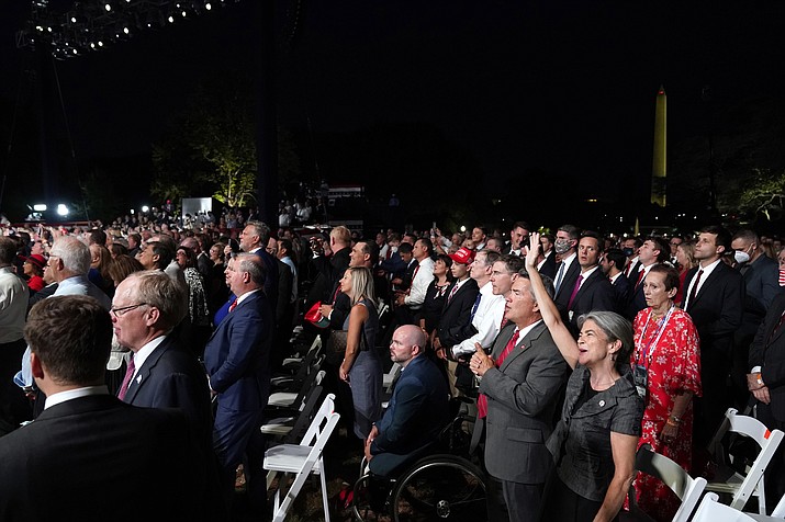 With the Washington Monument in the background, a crowd on the South Lawn of the White House watches the Republican National Convention as it plays on a screen on the fourth day of the convention, Thursday, Aug. 27, 2020, in Washington. (AP Photo/Alex Brandon)