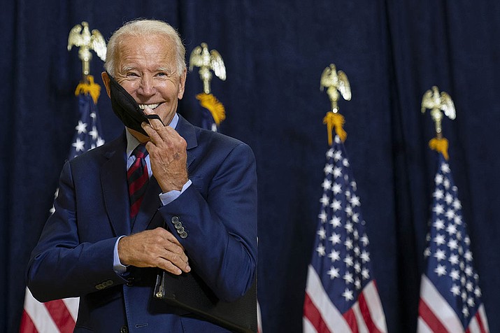 Democratic presidential candidate former Vice President Joe Biden smiles as he puts on his face mask after speaking to media in Wilmington, Del., Friday Sept. 4, 2020. (Carolyn Kaster/AP)