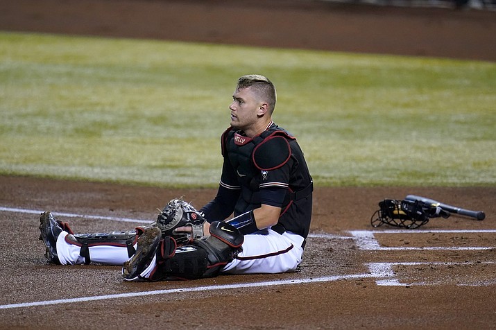 Arizona Diamondbacks catcher Carson Kelly sits in front of home plate after Seattle Mariners' Kyle Seager scored during the first inning of a baseball game Saturday, Sept. 12, 2020, in Phoenix. (Ross D. Franklin/AP)