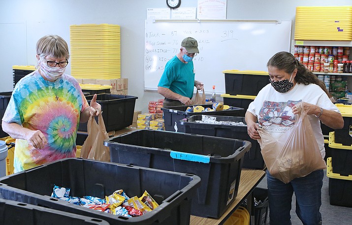 As part of the Hungry Kids Project 2020-21 distribution on Wednesday, Sept. 9, 2020, volunteers Sue McBride, left, and Jessie Springs assemble bags and ready them for distribution through local campuses. (CVUSD/Courtesy)
