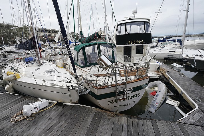 Storm damaged boats sit at the dock in a marina, Thursday, Sept. 17, 2020, in Pensacola, Fla. Rivers swollen by Hurricane Sally's rains threatened more misery for parts of the Florida Panhandle and south Alabama on Thursday, as the storm's remnants continued to dump heavy rains inland that spread the threat of flooding to Georgia and the Carolinas.(AP Photo/Gerald Herbert)