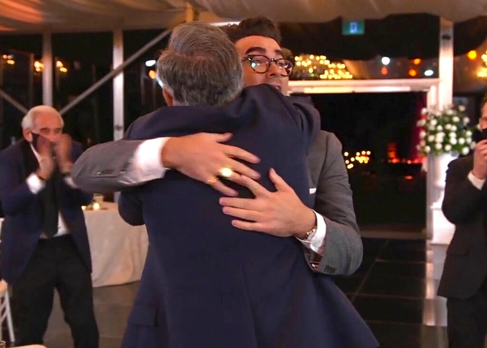 In this video grab captured on Sept. 20, 2020, courtesy of the Academy of Television Arts & Sciences and ABC Entertainment, Eugene Levy, left, hugs his son Daniel Levy, winner of the award for outstanding writing for a comedy series for "Schitt's Creek" during the 72nd Emmy Awards broadcast. (The Television Academy and ABC Entertainment via AP)
