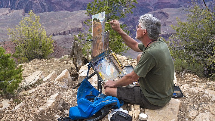 Highlands Center Bill painting seated on a rock Prescott Plein Air Art Festival.