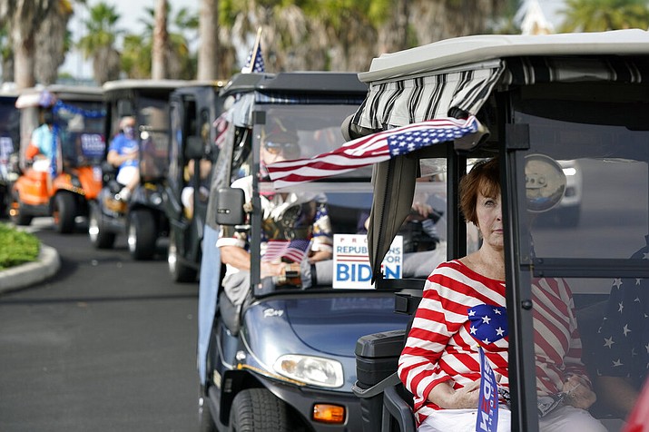 Carts line up before a parade of over 300 golf carts supporting Democratic presidential candidate former Vice President Joe Biden caravanned to the Sumter County Elections office to cast their ballots during early voting Wednesday, Oct. 7, 2020, in The Villages, Fla. (AP Photo/John Raoux)