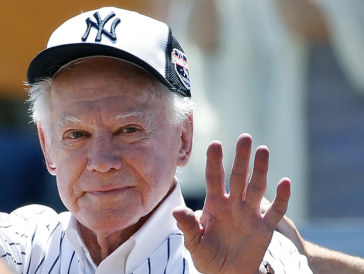 In this June 12, 2016 file photo, former New York Yankees pitcher Whitey Ford waves to fans from outside the dugout at the Yankees' annual Old Timers Day baseball game in New York. A family member tells The Associated Press on Friday, Oct. 9, 2020 that Ford died at his Long Island home Thursday night. (Kathy Willens, AP File)