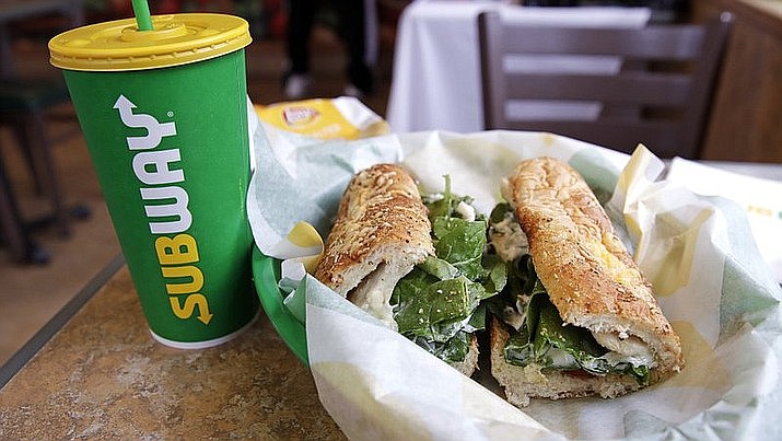 In this file photo, the Subway logo is seen on a soft drink cup next to a sandwich at a restaurant in Londonderry, N.H.. Ireland’s Supreme Court has ruled that bread sold by the fast food chain Subway contains so much sugar that it cannot be legally defined as bread. (AP Photo/Charles Krupa, File)