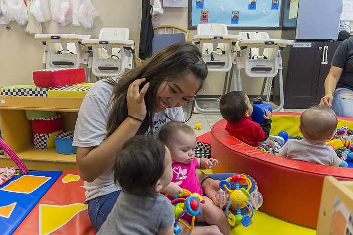 A child care staff member plays with a few children in a “Quality First” program by First Things First in Yavapai County. (First Things First/Courtesy)