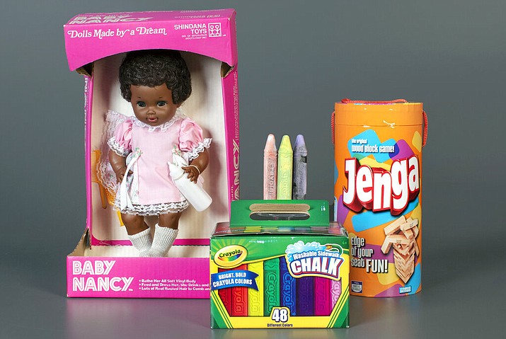 This photo, provided by the National Toy Hall of Fame, shows Baby Nancy, by Shindana Toys; Sidewalk Chalk, by Crayola; and Jenga, by Parker Brothers, left to right, that were inducted into the National Toy Hall of Fame on Thursday, Nov, 5, 2020. The honorees were chosen by a panel of experts from among 12 finalists and will be on permanent display inside The Strong National Museum of Play, in Rochester, New York. (Victoria Gray/National Toy Hall of Fame via AP)