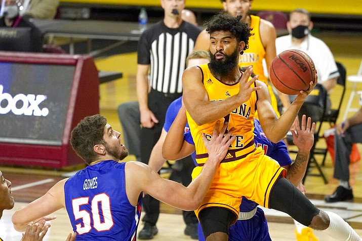 Arizona State guard Remy Martin, right, passes the ball around Houston Baptist center Ryan Gomes (50) during the first half of an NCAA college basketball game, Sunday, Nov. 29, 2020, in Tempe, Ariz. (AP Photo/Rick Scuteri)
