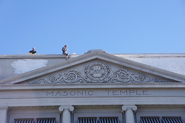 Local businessmen Charlie Arnold, left, and Chris Marchetti, right, volunteered to paint over the graffiti that appeared on the historic Masonic Temple building in downtown Prescott on Wednesday, Nov. 25, 2020. On Dec. 1, the two first applied a coat of primer, and then a coat of paint. (Cindy Barks/Courier)