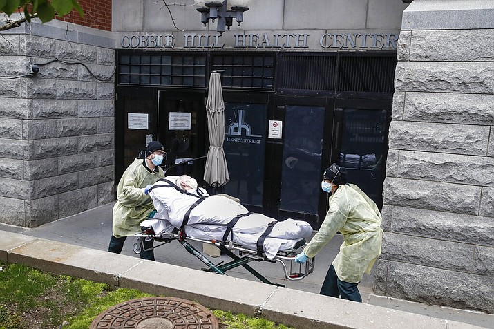 In this Friday, April 17, 2020 file photo, a patient is wheeled out of the Cobble Hill Health Center nursing home by emergency medical workers in the Brooklyn borough of New York. After 100,000 deaths ravaged the nation’s nursing homes and pushed them to the front of the vaccine line, they now face a vexing problem: Skeptical residents and workers balking at getting the shots. (AP Photo/John Minchillo, File)