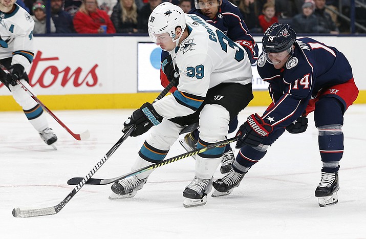 In this Jan. 4, 2020, file photo, San Jose Sharks' Logan Couture, left, skates the puck upice as Columbus Blue Jackets' Gustav Nyquist, of Sweden, defends during the third period of an NHL hockey game in Columbus, Ohio. The Sharks never managed to climb out of the deep hole they dug with a slow start last season. Avoiding the same fate this year is a high priority for the team, especially the condensed 56-game schedule and the extended road trip they are on to start this season. (Jay LaPrete, AP File)
