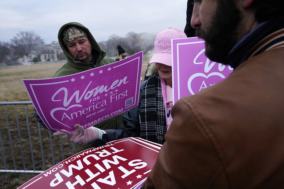 People hand out signs Wednesday, Jan. 6, 2021, in Washington, at a rally in support of President Donald Trump called the "Save America Rally." (AP Photo/Jacquelyn Martin)