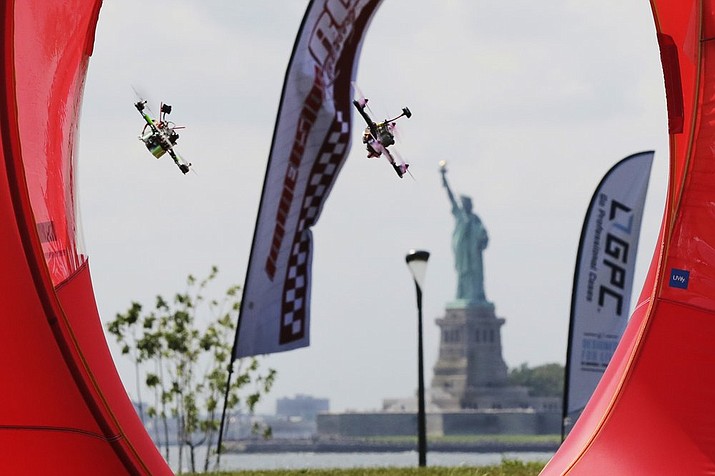 Pilots fly their small racing drones through an obstacle course for the National Drone Racing Championship on Governors Island, a former military installation in New York Harbor, Friday, Aug. 5, 2016. A major sports book is now taking bets on aerial drone races. (AP Photo/Richard Drew, File)