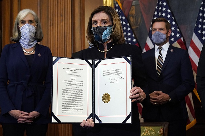 House Speaker Nancy Pelosi of Calif., displays the signed article of impeachment against President Donald Trump in an engrossment ceremony before transmission to the Senate for trial on Capitol Hill, in Washington, Wednesday, Jan. 13, 2021. (Alex Brandon/AP)