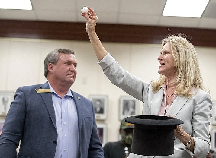 Outgoing Dickinson, Texas mayor Julie Masters, right, holds up a ping-pong ball bearing the name of Sean Skipworth at Dickinson City Hall on Thursday, Jan. 7, 2021. The drawing settled a tie between Dickinson mayoral candidates Jennifer Lawrence and Sean Skipworth. (Stuart Villanueva/The Galveston County Daily News via AP)