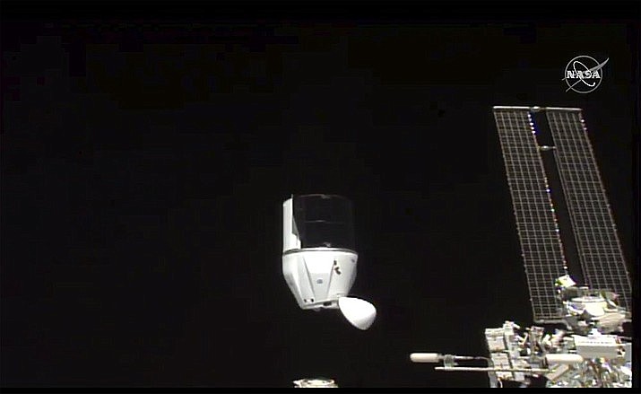 This photo provided by NASA shows SpaceX's Dragon undocking from International Space Station on Tuesday, Jan. 12, 2021. SpaceX's Dragon cargo capsule undocked with 12 bottles of Bordeaux wine and hundreds of snippets of Merlot and Cabernet Sauvignon vines. The capsule is aiming for a splashdown in the Gulf of Mexico off the Florida coast Wednesday night. (NASA via AP)