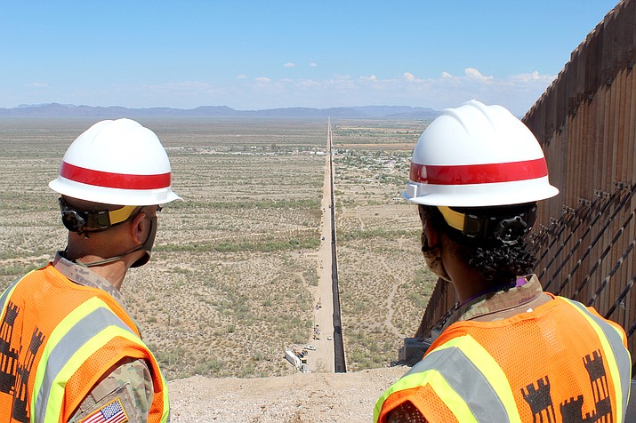 Two Army Corps of Engineers officers look down the U.S.-Mexico border near Lukeville in this 2020 file photo. President Joe Biden ordered a halt in construction of the wall, which reached 450 miles under the Trump recently celebrated the completion of 450 miles of wall – a program President Joe Biden has pledged to end. (Photo by George F. Jozens/U.S. Army)