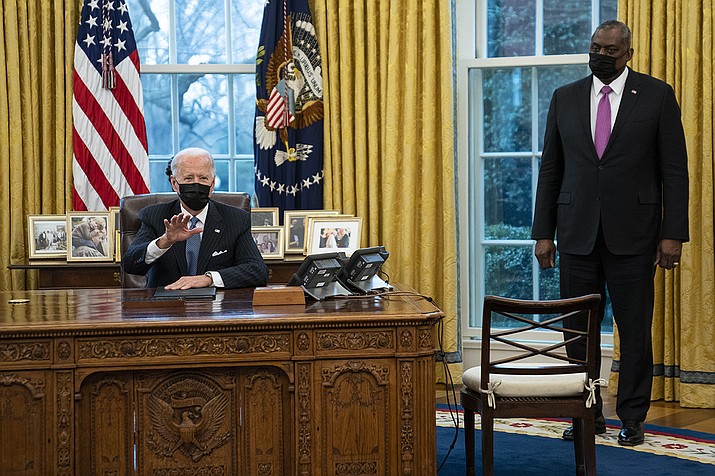 Secretary of Defense Lloyd Austin listens as President Joe Biden speaks before signing an Executive Order reversing the Trump era ban on transgender individuals serving in military, in the Oval Office of the White House, Monday, Jan. 25, 2021, in Washington. (Evan Vucci/AP)