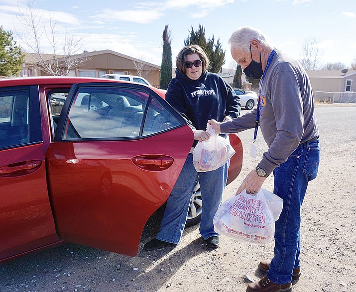 A Chino Valley Unified School District bus driver hands out meals at the Bottlebrush-James bus stop on Thursday, Jan. 21, 2021, as part of the district’s program to provide free meals to economically burdened families in the Chino Valley and Paulden communities. (Aaron Valdez/Review)