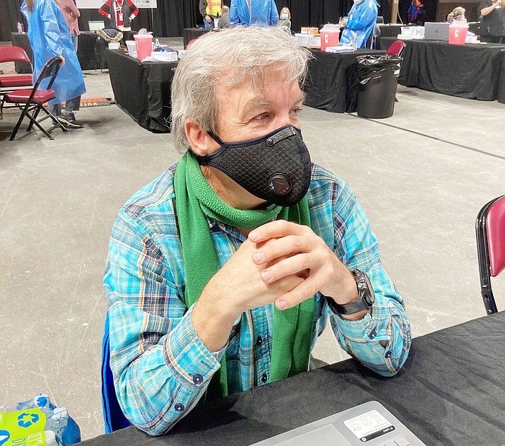Spectrum Healthcare volunteer Ferris Thompson observes the post-vaccination area Monday, Jan. 25, 2021, at the Findlay Toyota Center in Prescott Valley. He is there to make certain no one attending the mass vaccination event exhibits any side effects following the shots. A 15-minute waiting period is required following each vaccination. (Nanci Hutson/Courier)