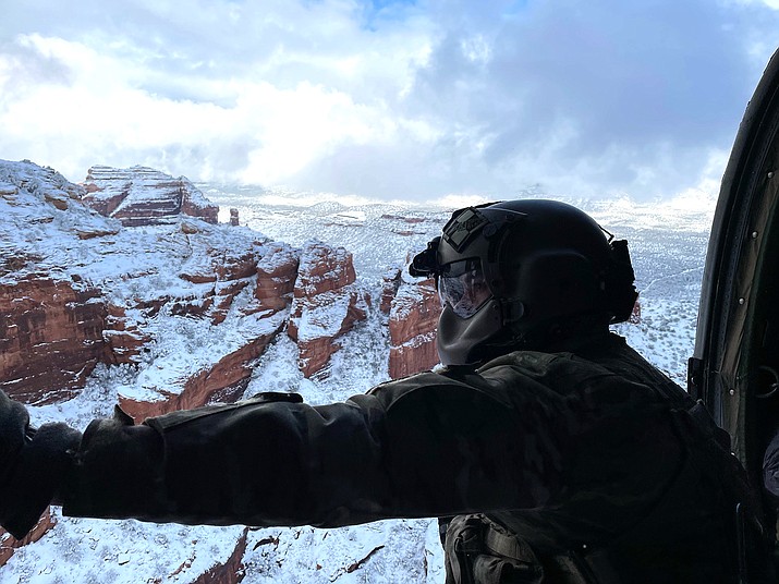 This photo provided by the Arizona National Guard shows a UH-60 Black Hawk crew with the Arizona National Guard during a rescue of three stranded climbers in snow covered Haribo Canyon in Sedona, Ariz. on Tuesday, Jan. 26, 2021. Crews in northern Arizona used a helicopter and a tracked vehicle to rescue a total of five people in two incidents in areas blanketed by heavy snow from a major storm, authorities said. (Maj. Kyle Key/Arizona National Guard via AP)
